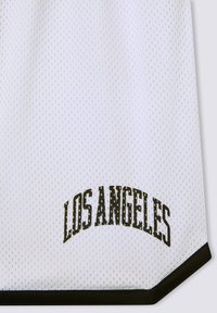 Canotta in tessuto a rete bianca con accenti neri. "LOS ANGELES" stampato in lettere nere in grassetto e ad arco vicino alla parte inferiore. Design dell'orlo esagonale.