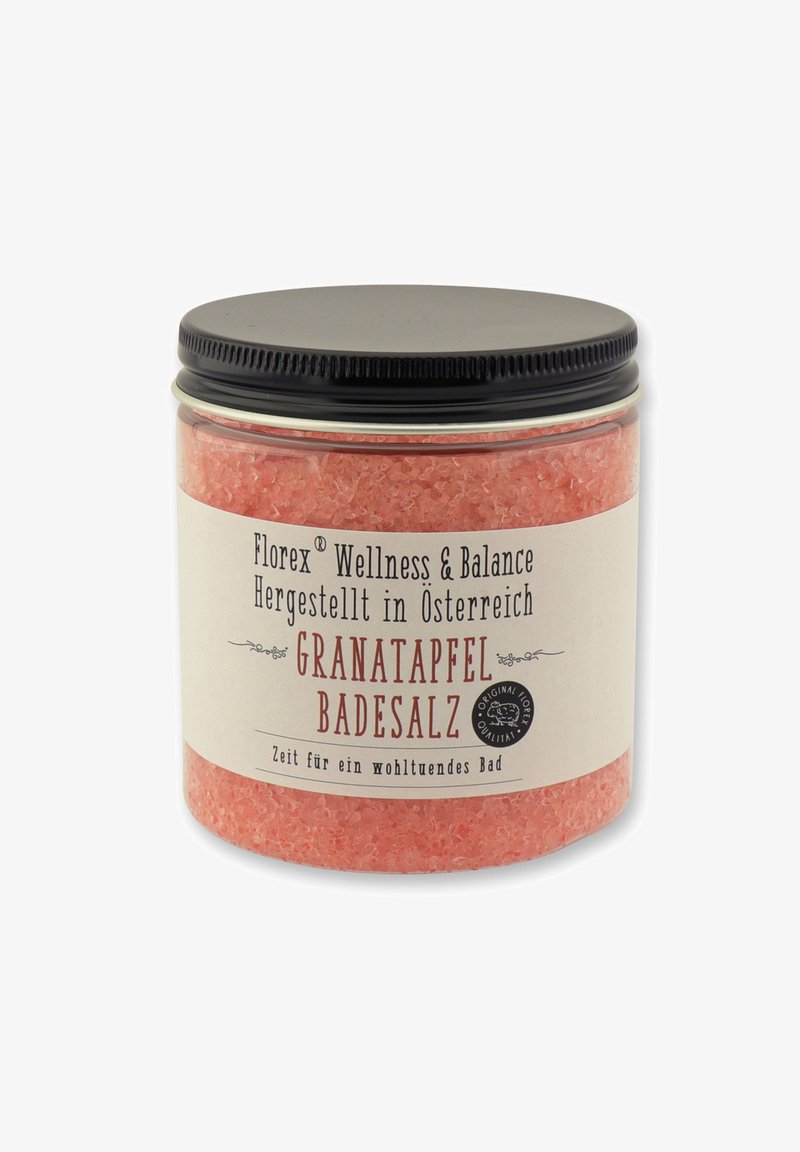 Pink bath salt in a transparent jar with a black lid. Label features text detailing the product's brand and name in various fonts.