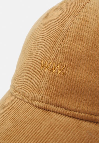 Corduroy cap in warm beige with wavy texture. Features embroidered "W.A.W." in gold. Classic six-panel design with curved brim.