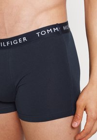 Boxers bleu marine en coton doux. Présentent une ceinture élastique avec le logo "TOMMY HILFIGER" en lettres blanches.