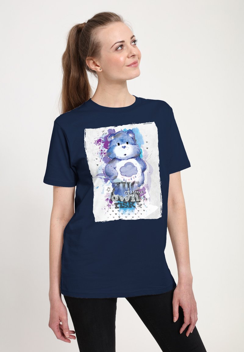 T-shirt in cotone blu navy caratterizzato da un'illustrazione ad acquerello di un orso con una nuvola, accentuata da schizzi di viola e testo sotto l'immagine.