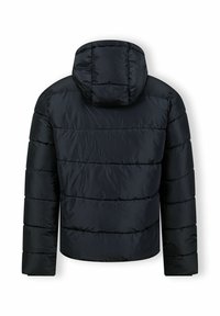 Mustat pehmeähuppuiset takki vaakasuoralla tilkkutäkillä, pitkät hihat ja hieman kaareva helma näkymässä takaa.