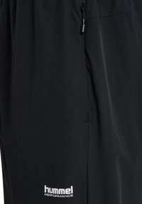 Zwarte sportbroek gemaakt van ademend materiaal, met een broekband met trekkoord en een wit "hummel PERFORMANCE" logo aan de zijkant.