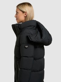 Doudoune noire avec un col montant, des poches zippées et un écusson logo. Texture lisse et matelassée avec une silhouette ajustée. Design avec capuche.