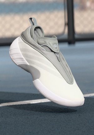 Sandă cu un model sport gri, cu un superior neted, accente din plasă și închidere cu fermoar. Dispune de o talpă intermediară albă și o talpă exterioară texturată pentru aderență.