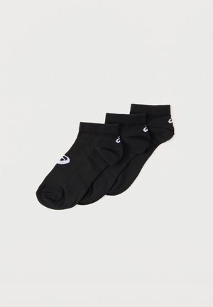Tres pares de calcetines tobilleros negros con un pequeño logo blanco en el lateral, dispuestos superpuestos sobre un fondo claro y liso.