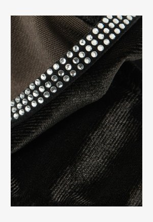 Tela negra drapeada con una fila de piedras de strass transparentes a lo largo del borde. La textura parece suave con un ligero brillo.