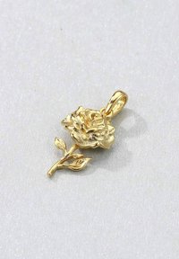 Pendente d'oro a forma di rosa con petali dettagliati e un gambo curvo, caratterizzato da due foglie. La superficie ha una finitura texturizzata.