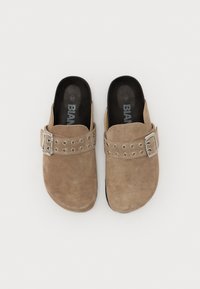 Tan suede clogs with silver buckle and circular grommet accents. Rounded toe, open back, and textured surface. Size 37.