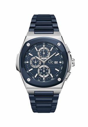 Marineblå kronografur med struktureret urskive, sølvfarvede detaljer og gummirem. Har under-Ure, tachymeter og metalhus.