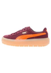 Baskets PUMA Suede en bordeaux avec une bande orange, dotées d'une tige en daim texturé et d'une semelle épaisse en caoutchouc translucide.