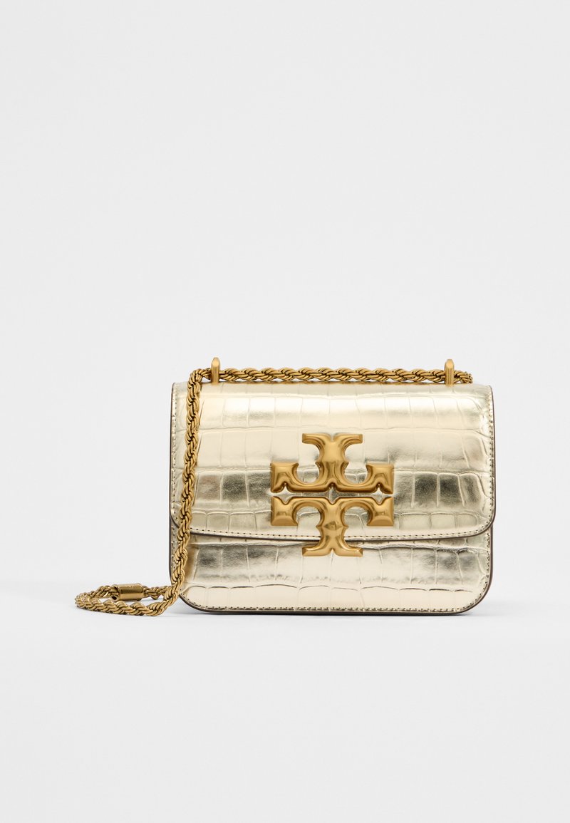 Goldfarbene metallische Tasche mit krokodilgeprägter Textur, ausgestattet mit einem herausragenden goldenen Logo und einem geflochtenen Kettenriemen. Rechteckige Form, elegantes Design.