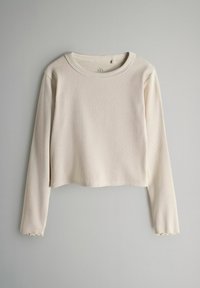 Kremowy, prążkowany crop top z długim rękawem, okrągłym dekoltem i falbaniastymi mankietami, wykonany z miękkiego materiału.