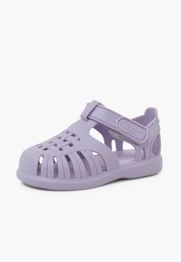Purple rubber sandal with cut-out design, adjustable strap, and textured sole for grip. Lightweight and flexible construction.