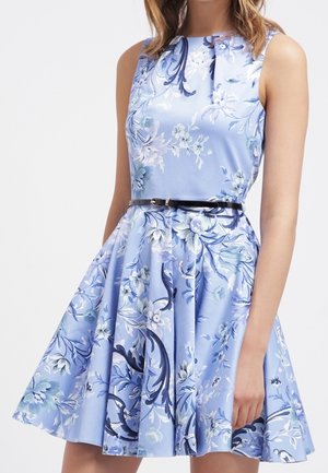 Abito floreale in tessuto azzurro chiaro, senza maniche con corpetto aderente, gonna ampia, cintura nera e intricate fantasie floreali blu.