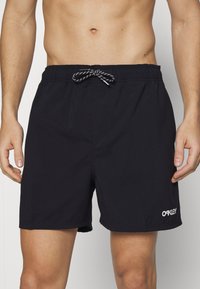 Juodi maudymosi šortai su elastinga juosmens juosta ir raišteliu. Gamine balta "Oakley" logotipas apatinėje kairėje pusėje. Lengvas audinys su glotnia tekstūra.
