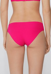 Różowe dno bikini w stylu hipster wykonane z gładkiego materiału. Charakteryzuje się niskim stanem i minimalnym zakryciem z wykończeniami bez szwów.