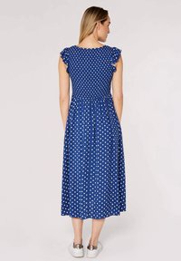 Blue polka dot dress with short ruffled sleeves, fitted bodice, and a flared skirt, made of lightweight fabric, knee-length with a smooth texture.