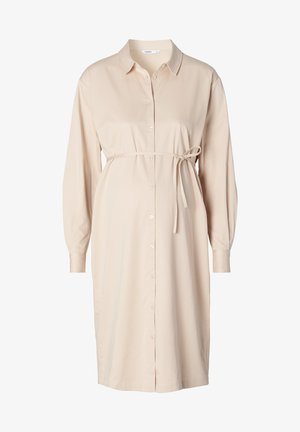Lys beige skjortekjole med lange ærmer, der er bundet i taljen. Lavet af glat stof med kraveskæring og afrundet kant.