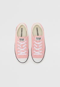 Rosa Leinenschuhe mit weißen Schnürsenkeln, schwarzen Gummisohlen und abgerundeten weißen Zehenkappen. Mit Converse All Star Branding auf der Zunge.