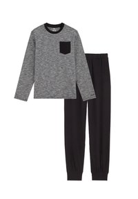 Siva majica s dolgimi rokavi in črno žepno podrobnostjo, v kombinaciji s črnimi hlačami z elastičnimi manšeti in pasom, vse iz gladkega materiala.