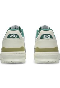 White and green ASICS sneakers with a textured design, padded collar, and rubber sole featuring a light green accent on the heel.