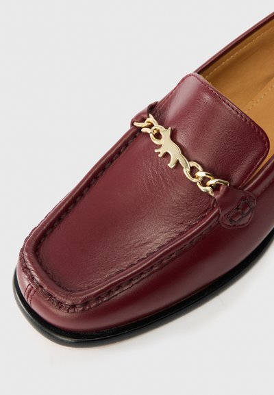 Βουργουνδίου δερμάτινο μοκάσεν με χρυσή αλυσίδα και γοητευτική γατοκέφαλη λεπτομέρεια, ραμμένα σχέδια και μαύρη καουτσούκ σόλα.