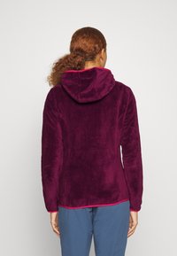Chaqueta de forro polar en púrpura profundo con una textura suave, capucha ajustable y acentos en rosa contrastante en el cuello y el bajo.