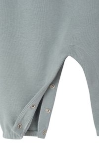 Hellgrauer Baumwoll-Overalls mit Druckknopfverschluss an der Seite, geschwungenem Ausschnitt und gerippten Bündchen für eine enganliegende Passform. Weiche, glatte Textur.