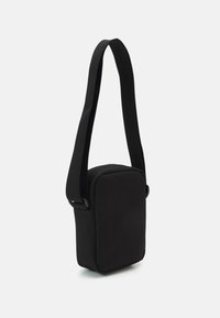Borsa a tracolla nera realizzata in tessuto testurizzato, con forma rettangolare, tracolla regolabile e design minimalista.