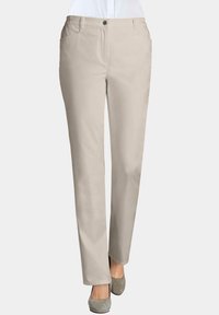 Beige broeken met een gladde textuur, rechte snit, voorzakken en een enkele knoopsluiting, gestyled met grijze hoge hakken.