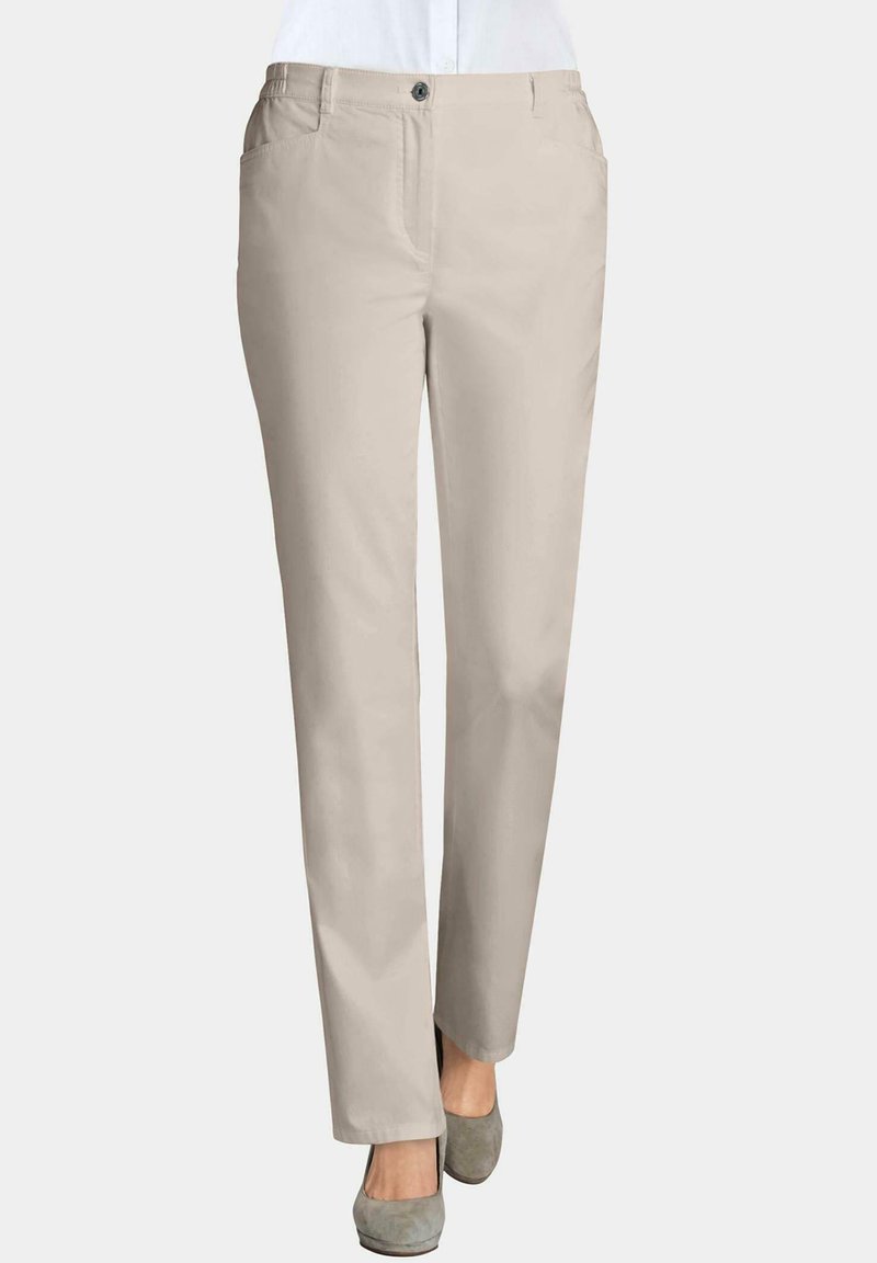 Beige broeken met een gladde textuur, rechte snit, voorzakken en een enkele knoopsluiting, gestyled met grijze hoge hakken.
