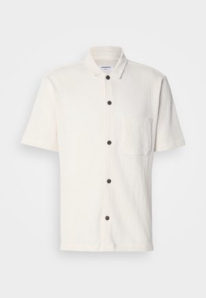 White short-sleeve shirt with a textured design, front buttons in dark brown, and a single chest pocket.