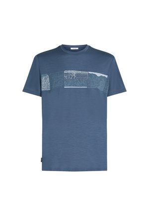 Sininen lyhythihainen T-paita, jossa on vaakasuora nauha abstrakteja, teksturoituja kuvioita rinnan kohdalla ja pyöreä kaula-aukko.