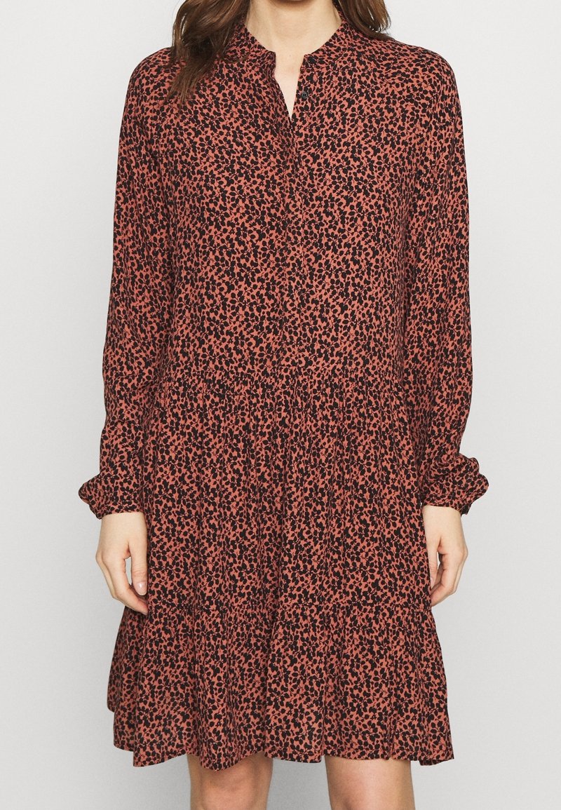 Dlouhý rukáv, šatové šaty po kolena v měděné barvě s černým květinovým potiskem, s knoflíkovou légou a nabíranou skládanou sukní. Jemná, lehká látka.