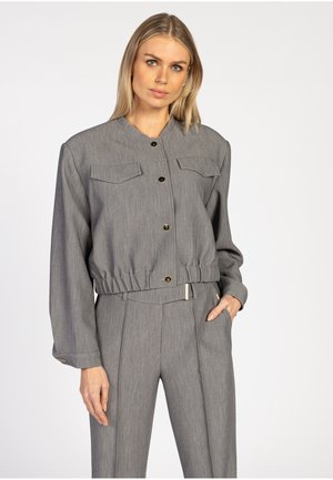 Grijze blazer met een kraag, twee borstzakken en gouden knopen. Heeft een geraffineerde tailleband en lange mouwen, gemaakt van een gestructureerde stof.