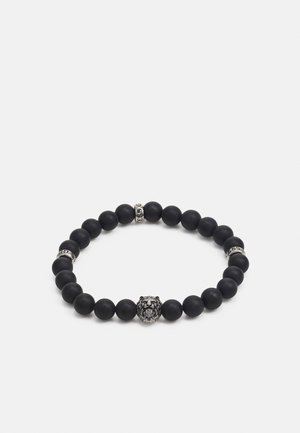 Bracelet en perles noires mat avec un centre en forme de tête de lion en argent et deux perles d'accent métalliques avec du texte gravé.