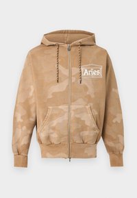 Ανοιχτό καφέ φούτερ καμουφλάζ με φερμουάρ, μπροστινές τσέπες, ρυθμιζόμενο κορδόνι στην κουκούλα και λευκό λογότυπο «Aries» στο αριστερό στήθος.