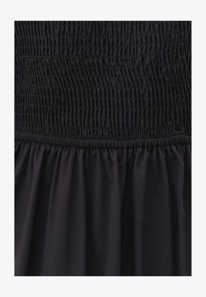 Czarna sukienka z marszczonym dekoltem, z falbaniastymi detalami, płynącą strukturą materiału i rozkloszowanym dołem.