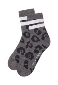 Calcetines grises con estampado de leopardo negro, que presentan dos franjas blancas en la parte superior. Textura acanalada y nombre de la marca impreso en blanco.