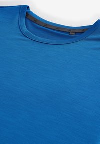 Maglietta sportiva blu con scollo rotondo e nastro interno nero sul colletto con piccoli loghi triangolari su sfondo bianco.