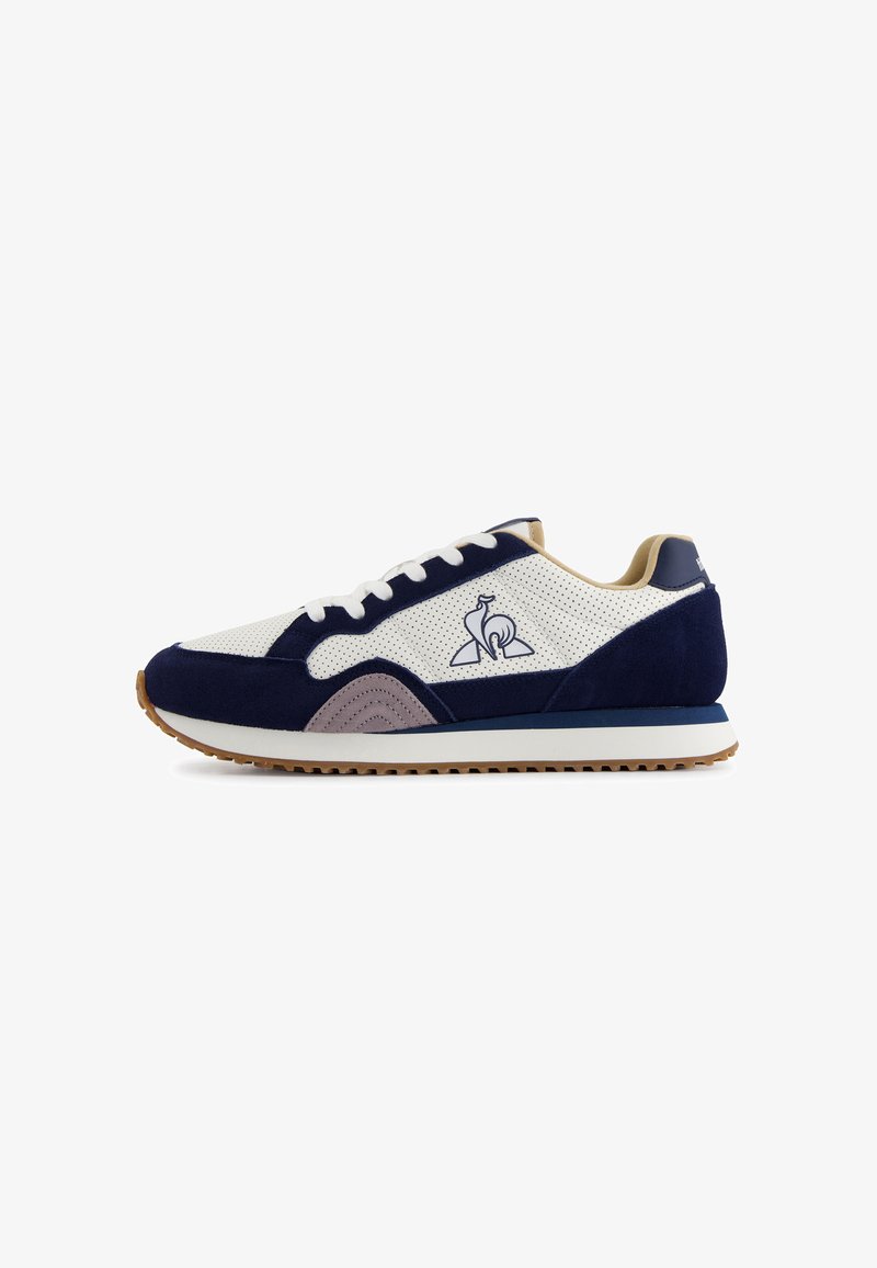 Zapatillas deportivas en azul marino y blanco, hechas de material de ante y malla. Presentan un logo distintivo, acentos texturizados y una suela de goma.