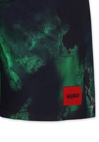 Pantaloni corti blu scuro con un motivo astratto verde, caratterizzati da un'etichetta rettangolare rossa con testo "HUGO". Realizzati in tessuto leggero.