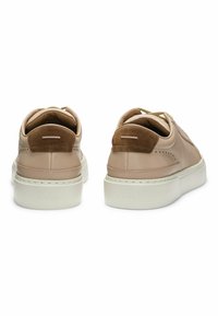 Beige leather sneakers with suede accents, round toe, lace-up design, and a white platform sole featuring engraved logo at the back.