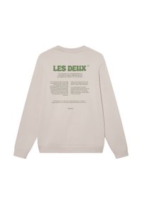 Világos bézs pulóver, kerek nyakkivágással, bordás mandzsettákkal és textúrált hátoldalú nyomattal, zöld betűzéssel és szöveges részletekkel.