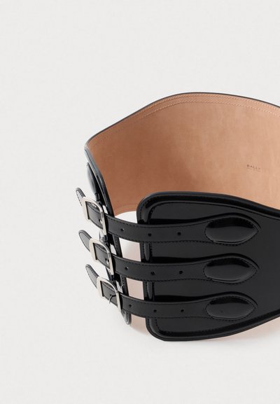 Zwarte leren tailleband met drie verstelbare gespsluitingen, een gladde buitenkant en een zachte beige binnenkant met een subtiele merklayout.