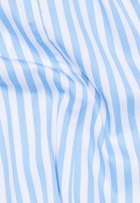 Tessuto a righe in bianco e azzurro chiaro, texture liscia, con linee verticali di larghezze variabili e dettagli di cucitura visibili.