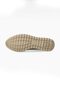 Semelle de sneaker en caoutchouc beige clair, présentant un motif texturé et rainuré pour l'adhérence, avec un logo circulaire au talon.
