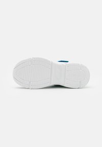 Suola di sneaker bianca con superficie testurizzata, caratterizzata da scanalature e motivi per una maggiore aderenza. Accenti blu sui lati, design minimalista.