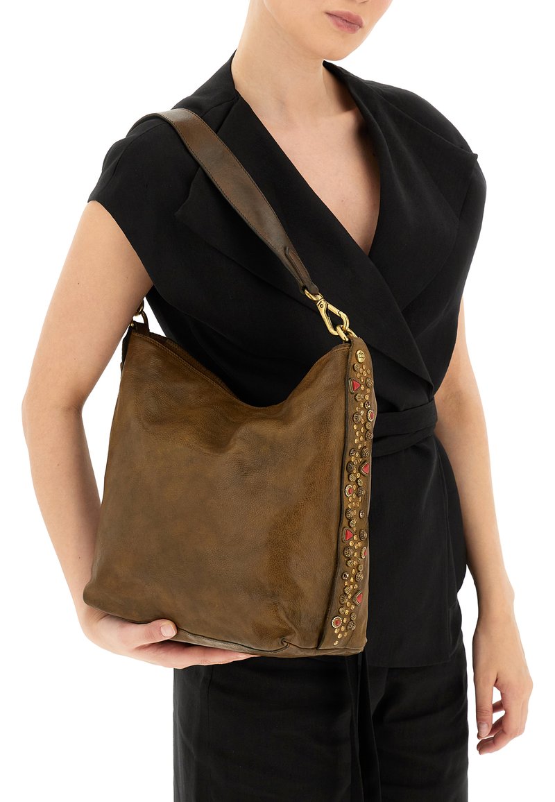 Borsa a spalla in pelle marrone caratterizzata da una forma morbida, decorata con borchie colorate su un lato e dotata di una tracolla robusta.